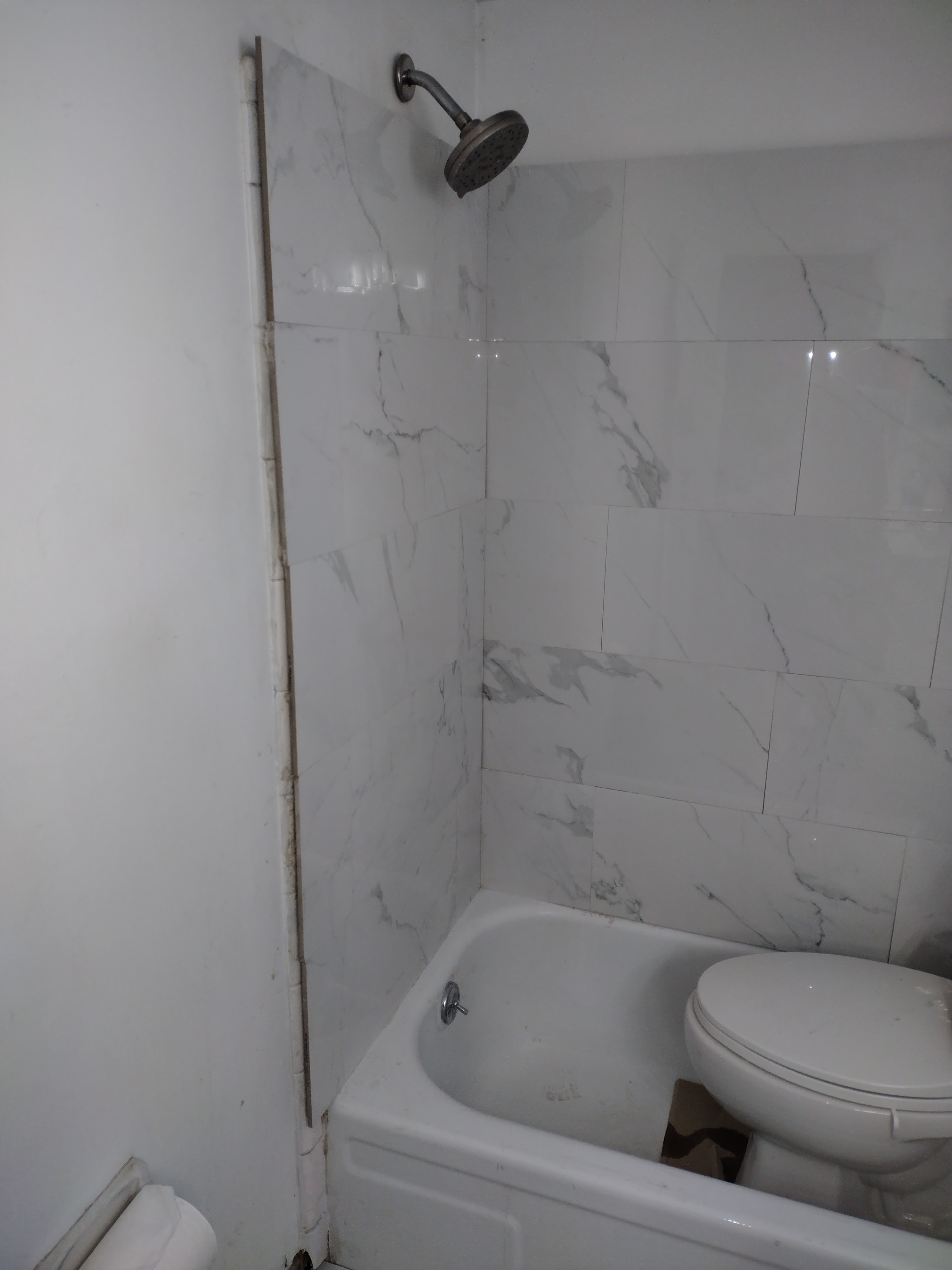 Marble tile installation in progress on bathroom walls