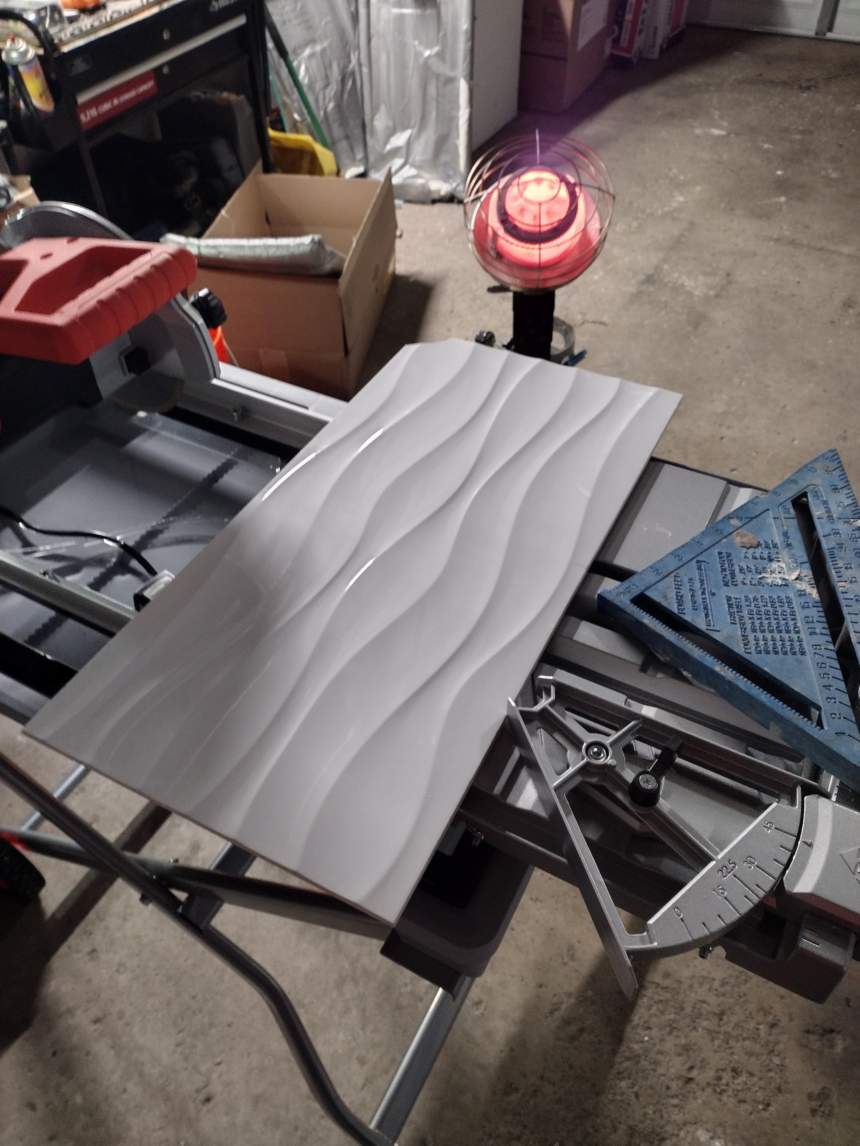 Cutting wave accent tile on wet saw in workshop