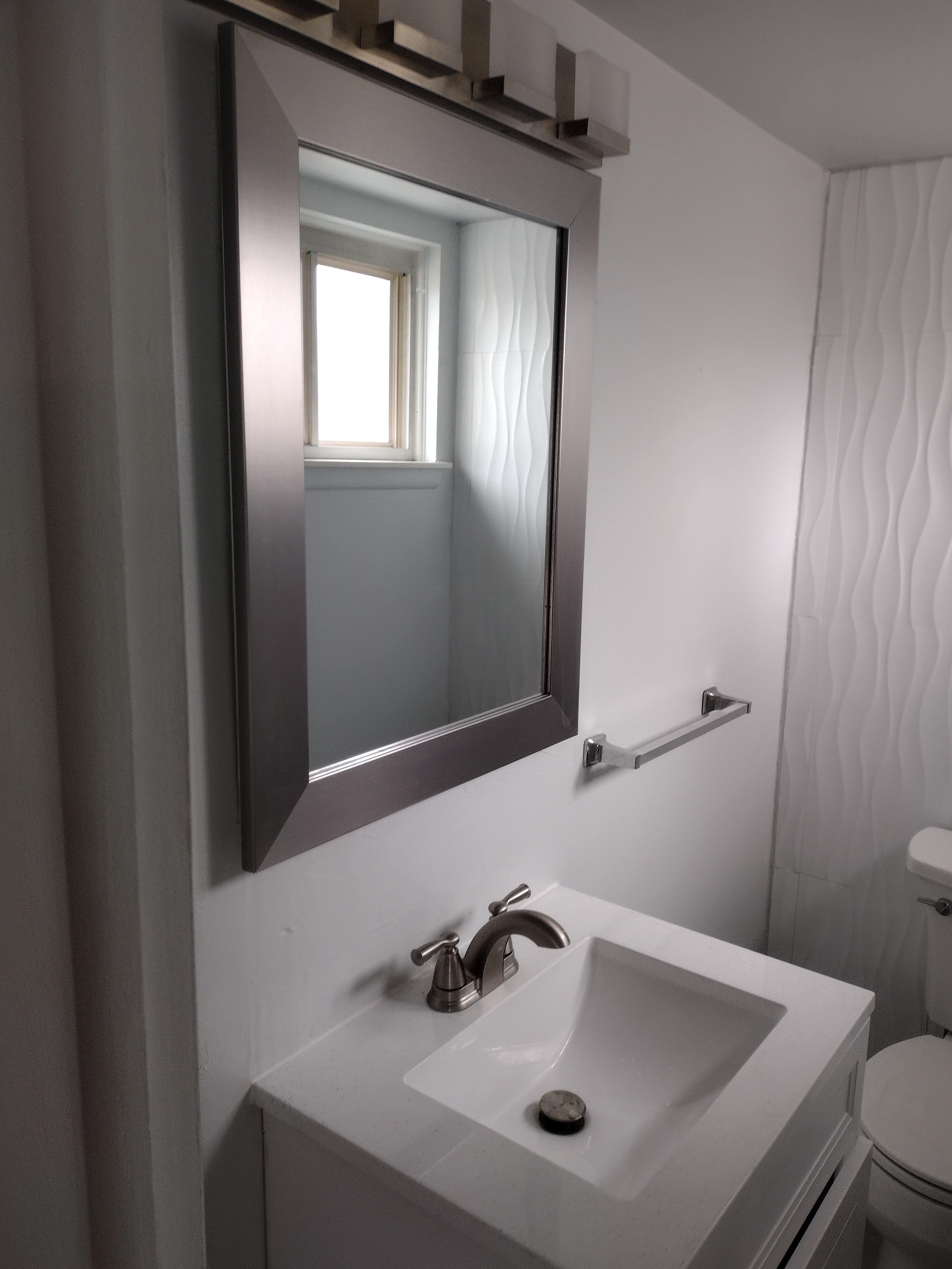 Completed vanity with brushed nickel mirror and light fixture