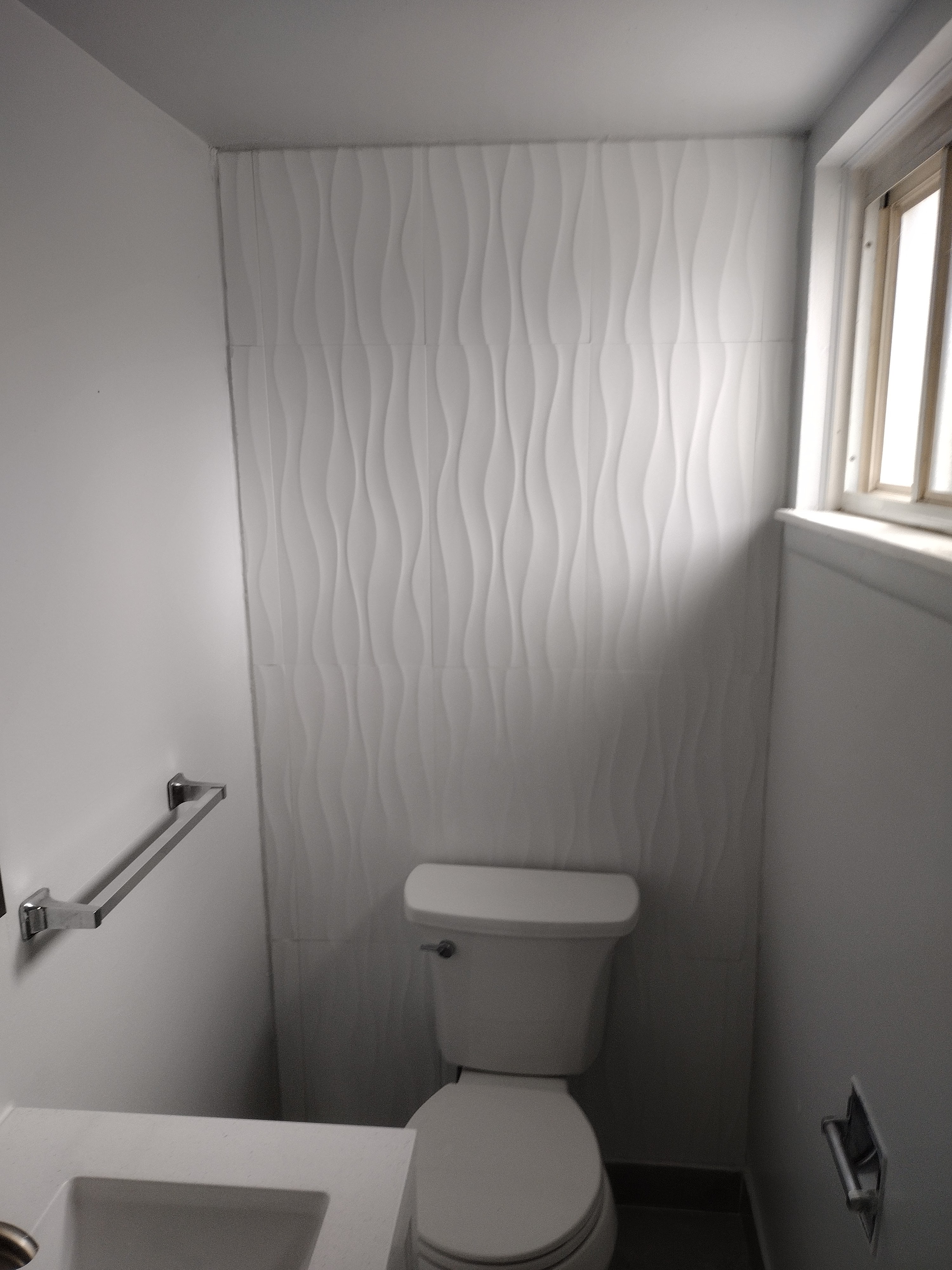 Wave tile accent wall behind toilet — finished detail