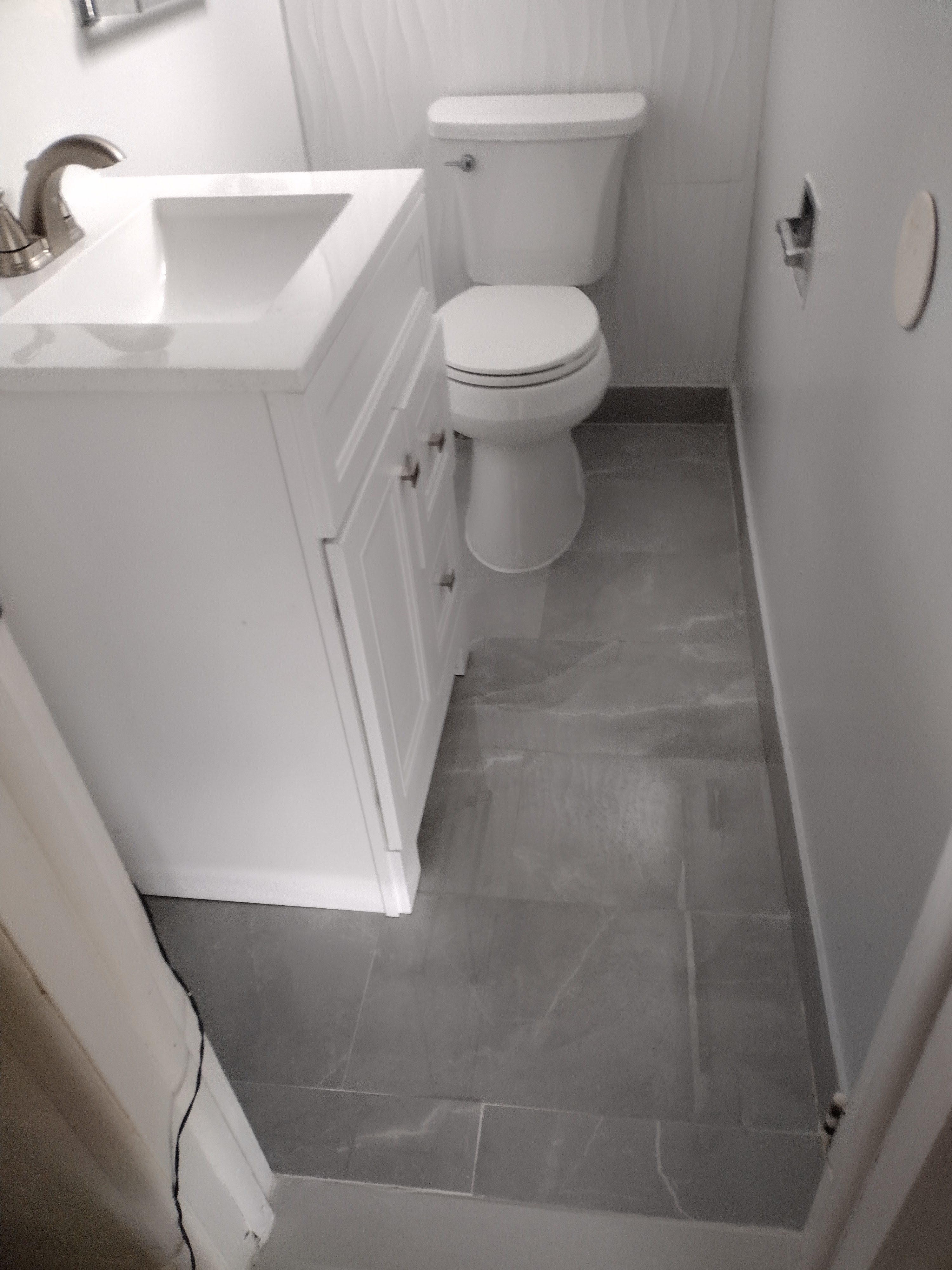 Full view of completed half-bath with porcelain tile floor