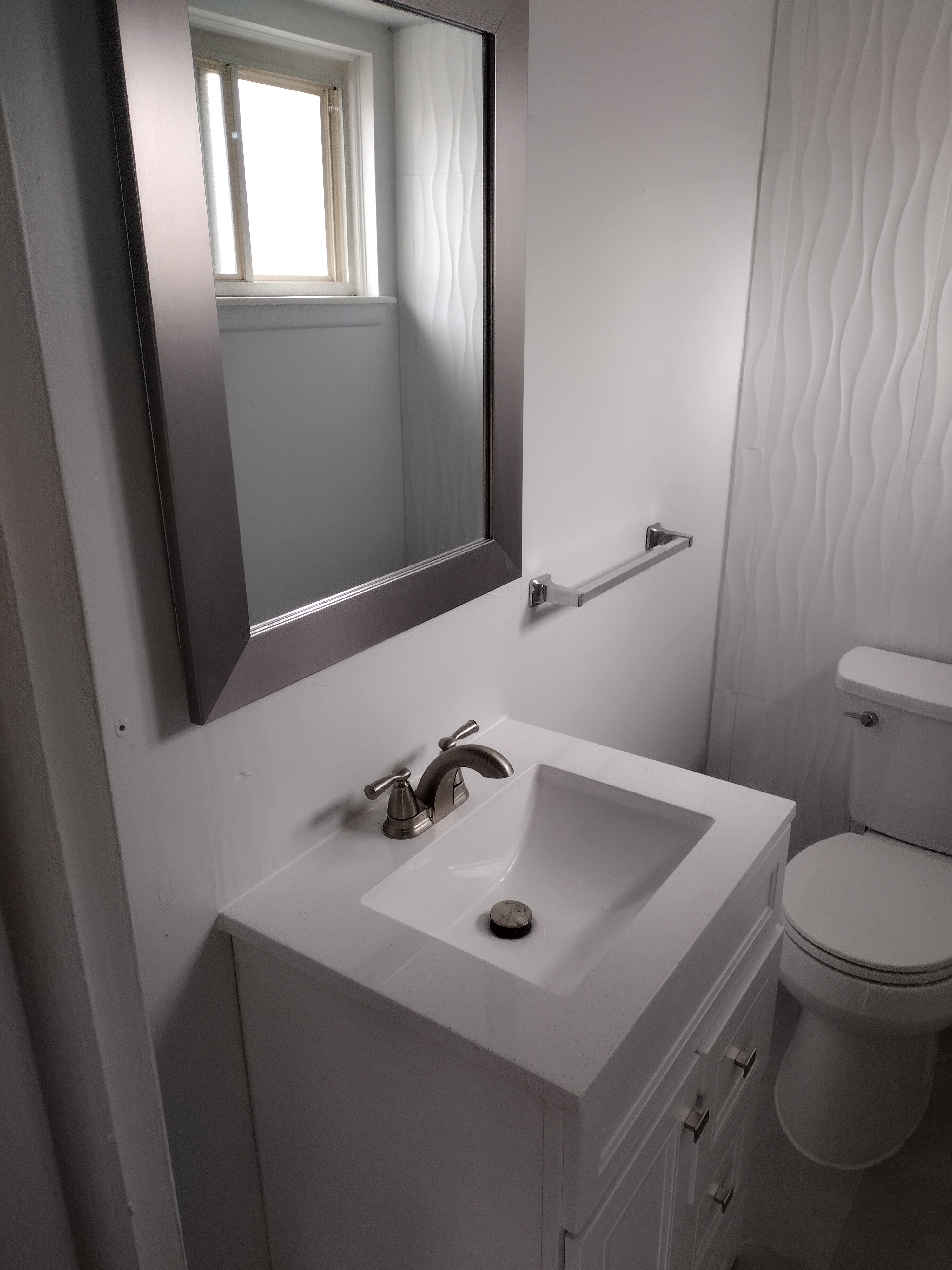Half-bath with wave tile accent wall